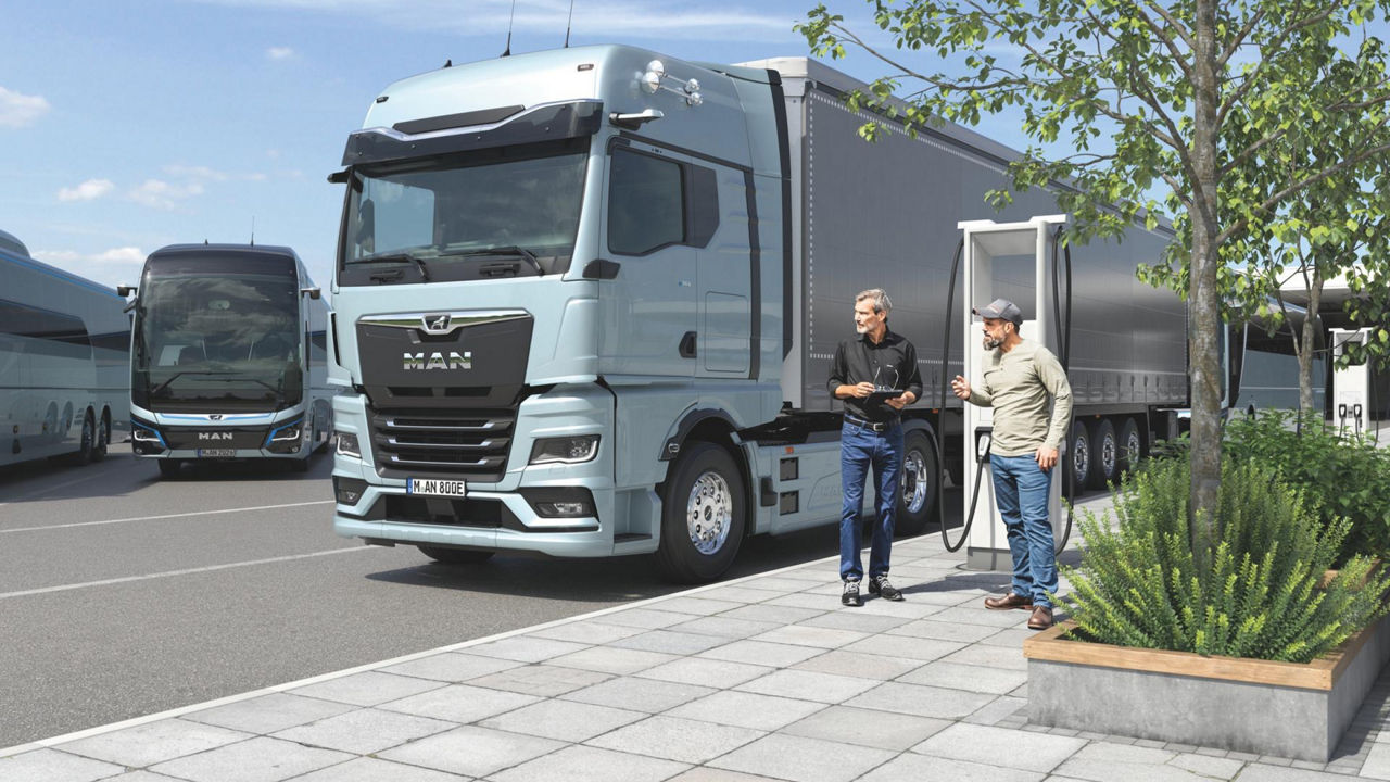 E-truck next to a charging station and two men